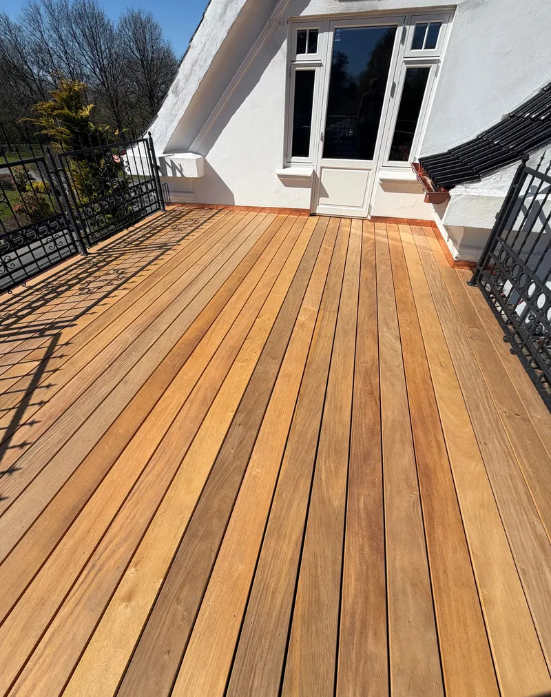 Ny terrasse på en altan ved et hvidt hus