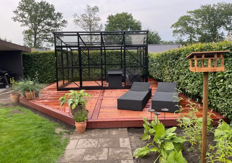 Terrasse med kant og liggestole i en have