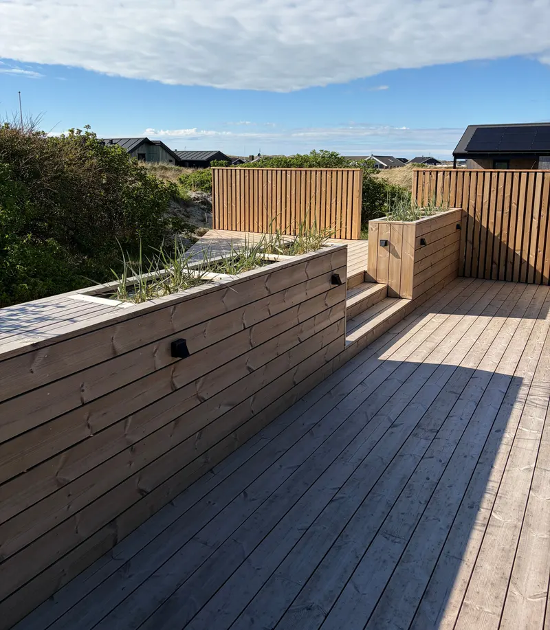 Terrasse med indbyggede plantekasser og trin