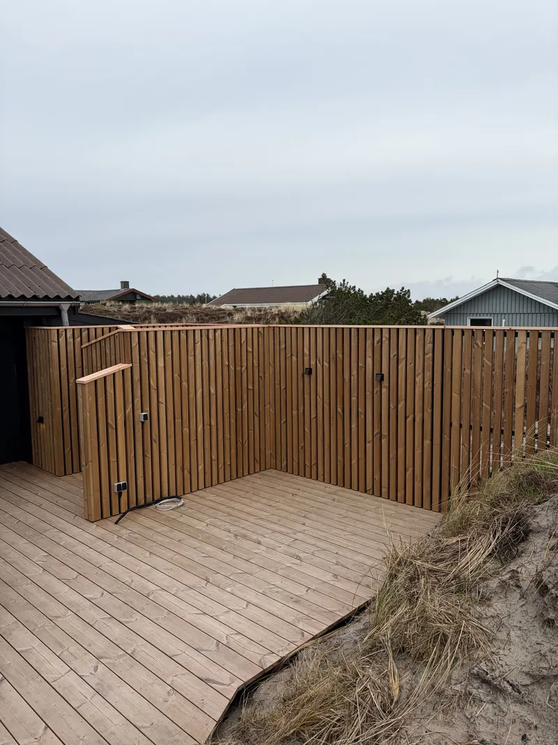 Ny terrasse med højt træhegn bag